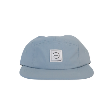 A sky blue nylon five-panel kid's hat with an adjustable velcro back and fabric eyelets on the side panels.