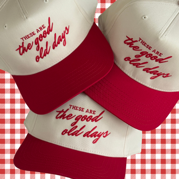 Three red and white baseball caps with 'These are the good old days' text on a red and white checkered background.