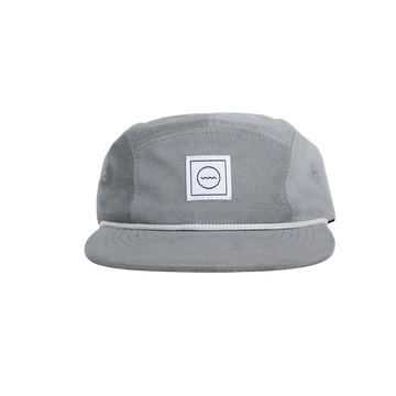 A gray corduroy five-panel hat with a white rope detail around the crown and a velcro back, featuring a white square logo with a symbol in the center.