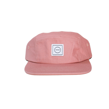 A blush pink five-panel cotton hat with an adjustable velcro back and fabric eyelets, suitable for kids.