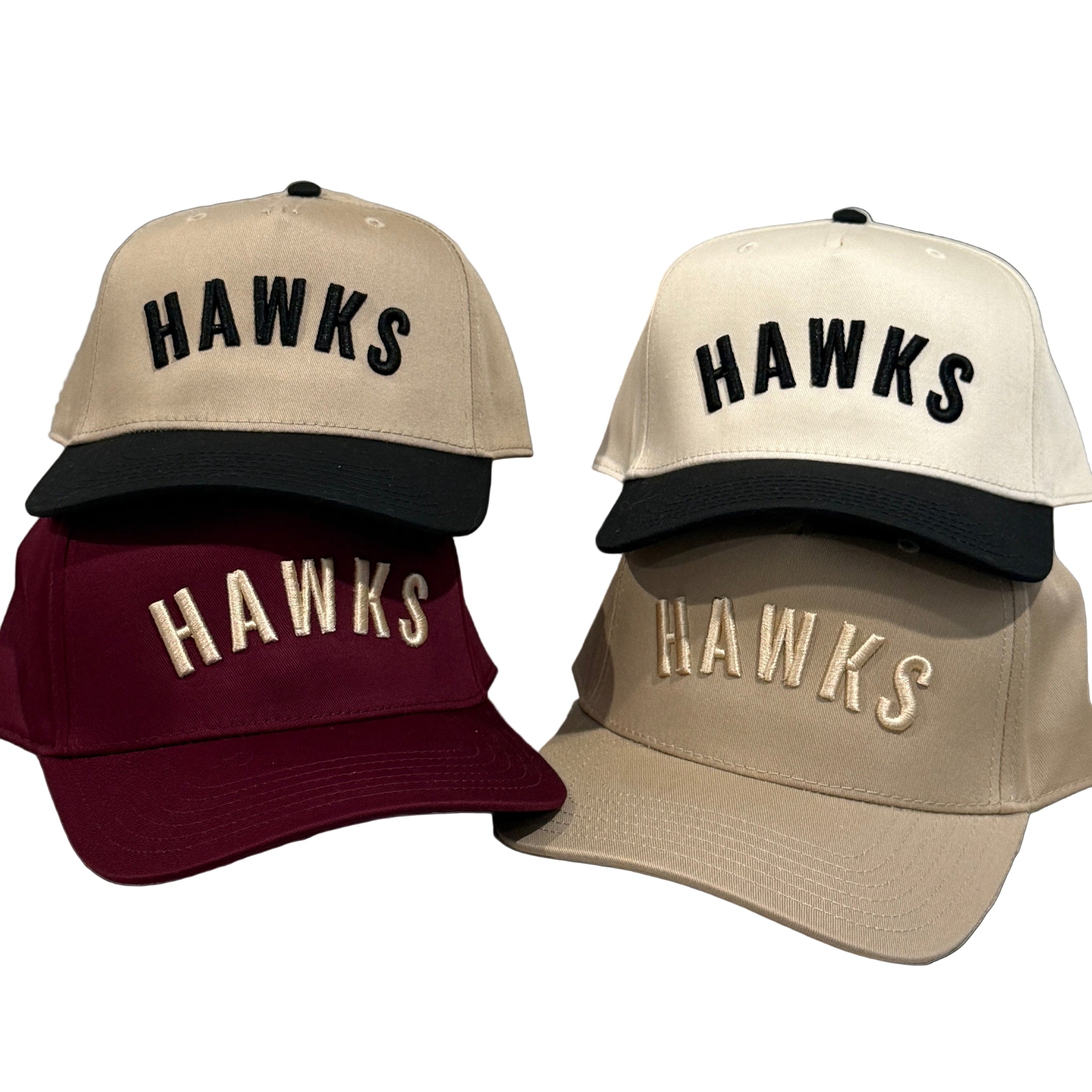 Four baseball caps with 'HAWKS' text in different colors on a textured surface.